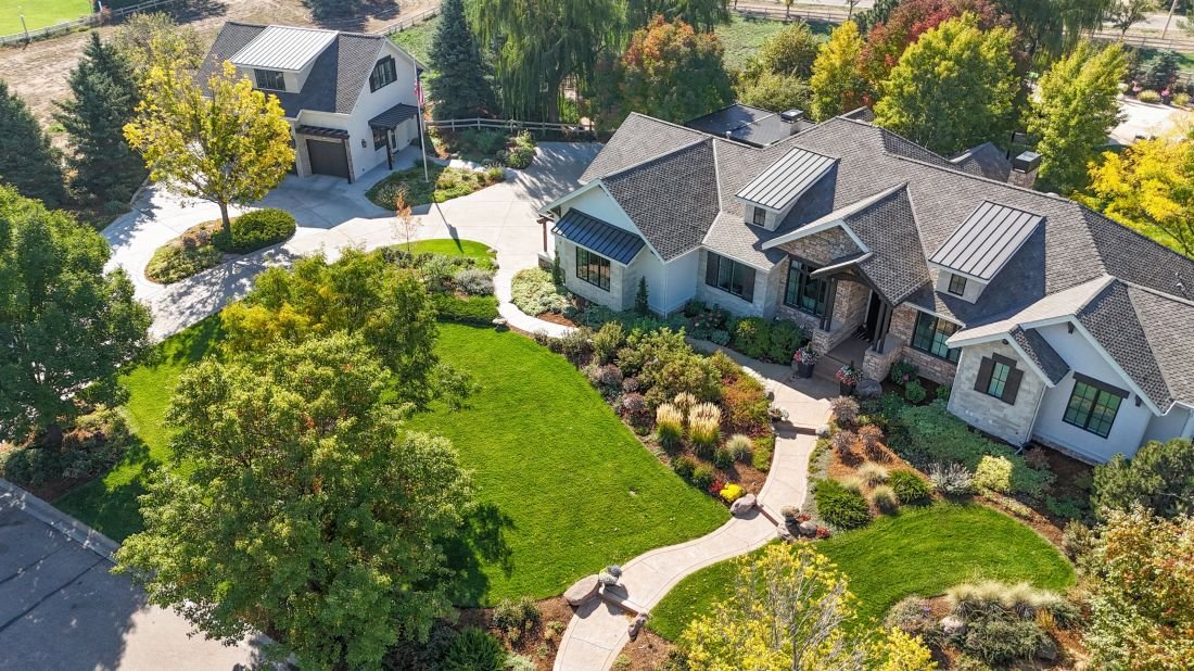 Aerial view of a landscaped Colorado home with lawn, trees and planting beds